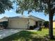 Charming single-story home with well-kept lawn, manicured bushes, and inviting red door at 11227 Summer Star Dr, Riverview, FL 33579