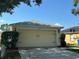 Attached two-car garage with a neutral-colored door and well-maintained landscaping at 11227 Summer Star Dr, Riverview, FL 33579