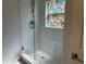 Modern walk-in shower featuring stylish white subway tile, a glass door, and a unique stained glass window at 11227 Summer Star Dr, Riverview, FL 33579