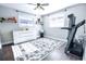 Bedroom with a treadmill and shelves, two windows, and wood floors, is bright and airy at 1438 S Hillcrest Ave, Clearwater, FL 33756