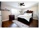 Spacious bedroom with dark wood floors, ceiling fan, dresser, and large bed with decorative pillows at 1438 S Hillcrest Ave, Clearwater, FL 33756