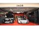 Garage with two sports cars, custom work benches and red epoxy floors at 1438 S Hillcrest Ave, Clearwater, FL 33756