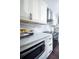 Modern kitchen with white cabinetry, quartz countertops, stainless steel appliances, and tile backsplash at 1438 S Hillcrest Ave, Clearwater, FL 33756