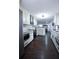 Open-concept kitchen features white cabinets, stainless steel appliances, tile backsplash, and dark wood floors at 1438 S Hillcrest Ave, Clearwater, FL 33756