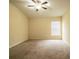 A bright, empty bedroom features a ceiling fan, neutral walls, and carpeted flooring at 16616 Magnolia Reserve Pl, Wimauma, FL 33598