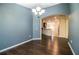 Dining room has hardwood floors, modern chandelier, and open access to kitchen at 16616 Magnolia Reserve Pl, Wimauma, FL 33598