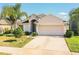 Lovely single-story home boasting a manicured lawn, mature palm, and a two-car garage at 16616 Magnolia Reserve Pl, Wimauma, FL 33598