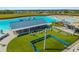 Aerial view of entertainment area boasting an outdoor stage, chairs, artificial turf and a pristine blue lagoon at 16815 Trite Bend St, Wimauma, FL 33598