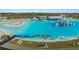 Aerial view of a community lagoon featuring clear blue water, a beach, and various watercraft activities at 16815 Trite Bend St, Wimauma, FL 33598