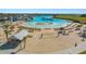 Aerial view of a community beach featuring white sand, clear water, beach chairs, and water activities at 16815 Trite Bend St, Wimauma, FL 33598