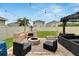 Inviting backyard with a brick fire pit, lounge chairs, and a well-maintained lawn at 16815 Trite Bend St, Wimauma, FL 33598