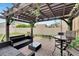 Charming backyard patio with a pergola, dining area, and cozy seating arrangement at 16815 Trite Bend St, Wimauma, FL 33598