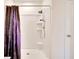 Clean bathroom featuring a shower with a purple floral curtain and a white tile surround at 16815 Trite Bend St, Wimauma, FL 33598
