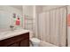 Bathroom featuring modern vanity, toilet, shelving, and shower with stylish curtain at 16815 Trite Bend St, Wimauma, FL 33598
