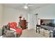 Cozy bedroom with a gray leather recliner, desk and TV, providing a comfortable retreat at 16815 Trite Bend St, Wimauma, FL 33598