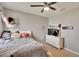 Bright bedroom with carpet, features a modern ceiling fan and a white dresser with a television at 16815 Trite Bend St, Wimauma, FL 33598