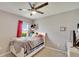 Comfortable bedroom features a ceiling fan, window with pink curtain, and a white bed frame at 16815 Trite Bend St, Wimauma, FL 33598