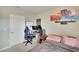 This bedroom has a light grey paint, a gaming desk and chair, and colourful wall art at 16815 Trite Bend St, Wimauma, FL 33598