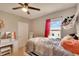 Cozy bedroom includes carpet, a ceiling fan, and a dresser with a vanity area and a large window at 16815 Trite Bend St, Wimauma, FL 33598