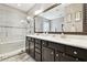 Stylish bathroom with double vanity, framed mirror, and a glass-enclosed shower with bench at 1796 Tonka Ter, Wesley Chapel, FL 33543