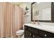 Elegant bathroom showcases a dark vanity, a large mirror, and a shower with a patterned curtain at 1796 Tonka Ter, Wesley Chapel, FL 33543