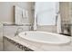 Elegant bathtub with tile surround, decorative accents, and window with natural light at 1796 Tonka Ter, Wesley Chapel, FL 33543