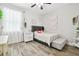 Bright bedroom features neutral walls, ceiling fan, modern wood-look floors, and decor accents at 1796 Tonka Ter, Wesley Chapel, FL 33543