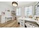 Modern bedroom with a white bed, desk, and decor, and light wood-look floors at 1796 Tonka Ter, Wesley Chapel, FL 33543