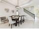 Bright dining room showcasing a wooden table with upholstered chairs, modern light fixture and stairway at 1796 Tonka Ter, Wesley Chapel, FL 33543