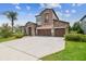 Attractive home with a three-car garage, a stone facade, and a well-manicured lawn at 1796 Tonka Ter, Wesley Chapel, FL 33543