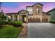 Elegant two-story home featuring stone accents, a three-car garage, and a beautifully landscaped front yard at 1796 Tonka Ter, Wesley Chapel, FL 33543