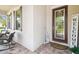 Inviting front porch with seating area and a decorative front door at 1796 Tonka Ter, Wesley Chapel, FL 33543