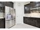 Kitchen featuring stainless steel refrigerator, dark cabinetry, and complementary backsplash at 1796 Tonka Ter, Wesley Chapel, FL 33543