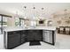 Open kitchen with dark cabinets, stainless steel appliances and view to living and dining areas at 1796 Tonka Ter, Wesley Chapel, FL 33543