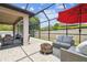 Inviting screened patio with ample seating, string lights, and a relaxing outdoor fire pit area at 1796 Tonka Ter, Wesley Chapel, FL 33543