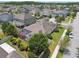 Aerial view showcasing a screened-in patio, lush landscaping, and a manicured lawn in the home's backyard at 1796 Tonka Ter, Wesley Chapel, FL 33543