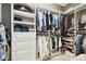 Spacious walk-in closet featuring custom shelving, drawers, and multiple hanging rods for optimal storage at 1796 Tonka Ter, Wesley Chapel, FL 33543