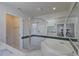 Bright bathroom featuring a glass shower, bathtub, and double sink vanity at 18918 Emerald Ridge Dr, Hudson, FL 34667