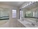 Bright bathroom featuring double sinks, large mirrors, and a glass shower at 18918 Emerald Ridge Dr, Hudson, FL 34667