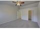 Spacious bedroom with neutral carpet, ceiling fan, closet, and an en-suite bathroom at 18918 Emerald Ridge Dr, Hudson, FL 34667