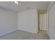 Bright bedroom with neutral carpet, closet, and a view to a hallway with a doorway at 18918 Emerald Ridge Dr, Hudson, FL 34667