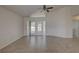 Open living room features tiled floors, a ceiling fan, and sliding glass doors to the backyard at 18918 Emerald Ridge Dr, Hudson, FL 34667