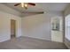 Spacious main bedroom with carpet, ceiling fan, closet, and view to the en-suite bathroom at 18918 Emerald Ridge Dr, Hudson, FL 34667