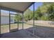 Enclosed patio overlooking a grassy backyard with mature trees and a wooden fence at 18918 Emerald Ridge Dr, Hudson, FL 34667