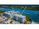Aerial view of waterfront condos with boat docks along bay, showcasing its coastal community at 19519 Gulf Blvd # 203, Indian Shores, FL 33785