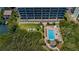 Aerial view of a condo with a pool, kayaks, and waterfront access amid lush greenery, showcasing luxury living at 19519 Gulf Blvd # 203, Indian Shores, FL 33785