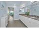 Open view of primary bathroom featuring double vanity and glimpse of bedroom with balcony at 19519 Gulf Blvd # 203, Indian Shores, FL 33785