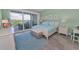 Bright bedroom featuring water view balcony access, wood floors, starfish decor, and stylish furnishings at 19519 Gulf Blvd # 203, Indian Shores, FL 33785
