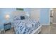 Bedroom featuring wood-look floors, nautical bedding, and a glimpse into the en-suite bathroom at 19519 Gulf Blvd # 203, Indian Shores, FL 33785