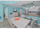 Dining room with seating for four and modern lighting, next to the kitchen at 19519 Gulf Blvd # 203, Indian Shores, FL 33785
